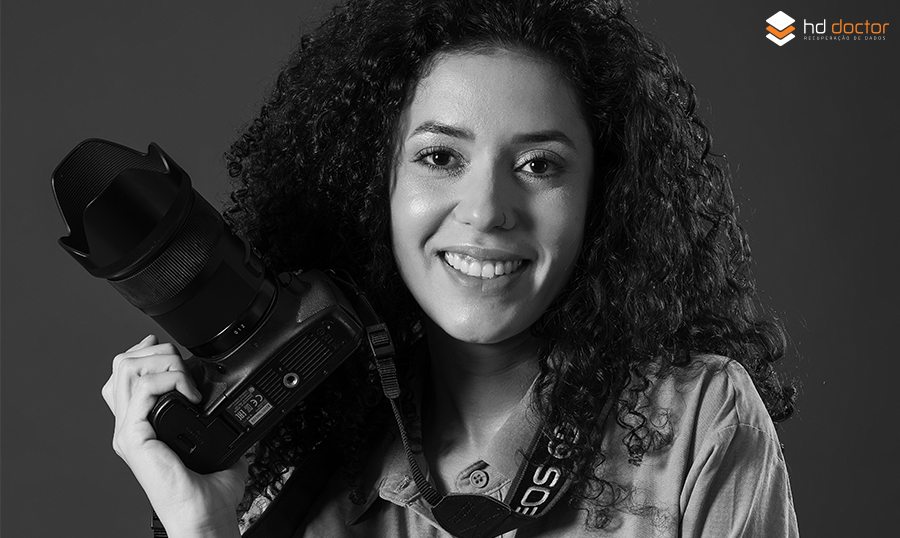 mulher sorrindo com câmera fotográfica na mão